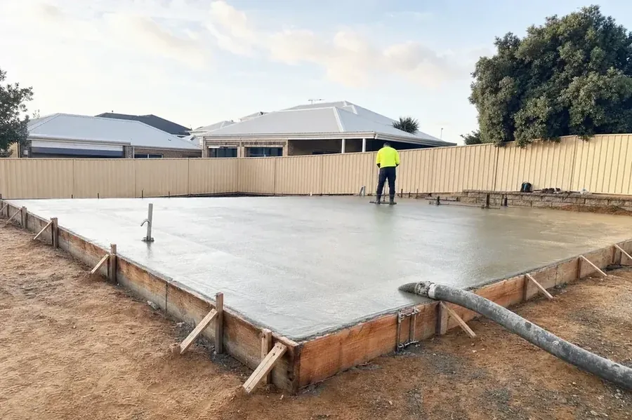 Freshly poured residential concrete slab on a Perth suburban block with a pump line