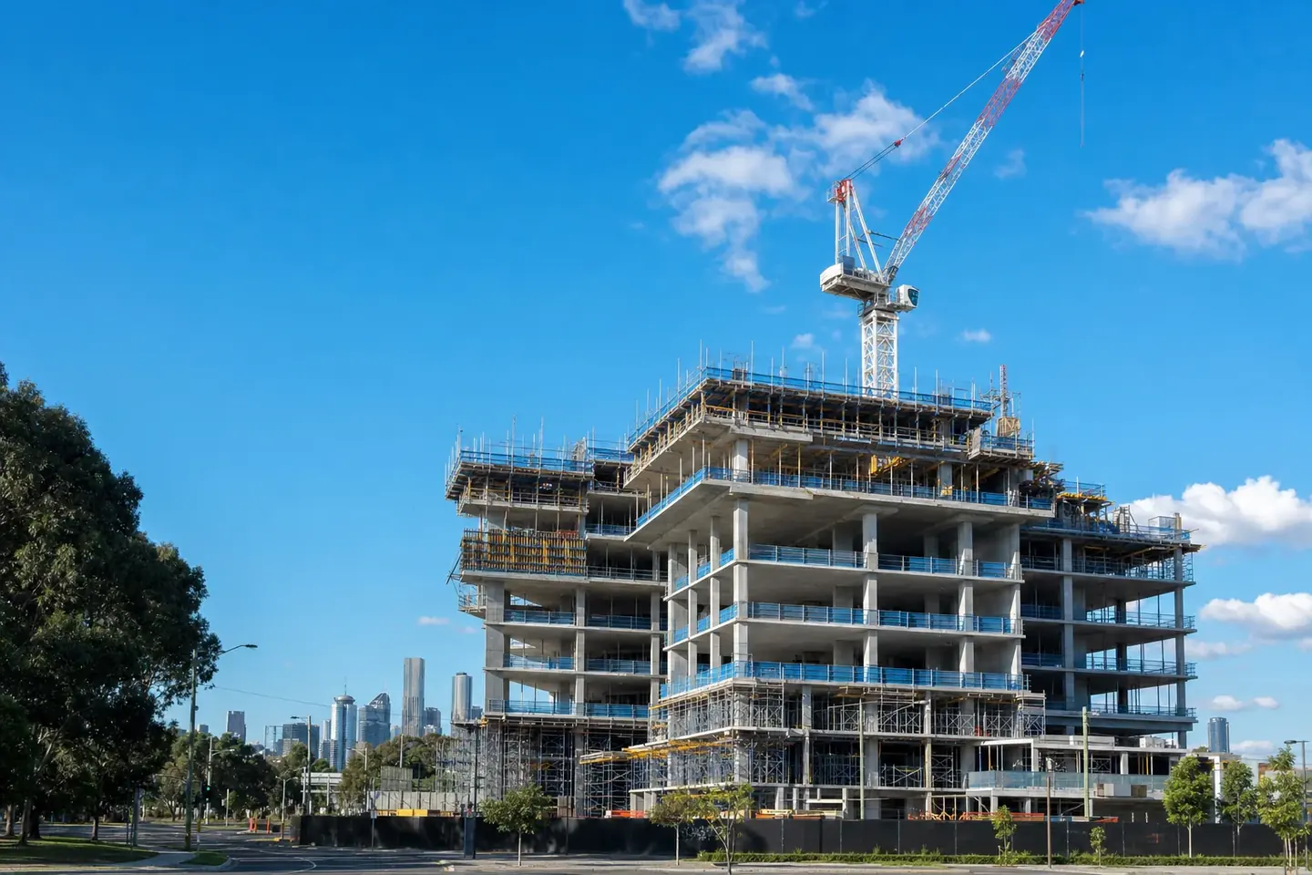 Mid-rise commercial building under construction with structural frame, scaffold and formwork in place