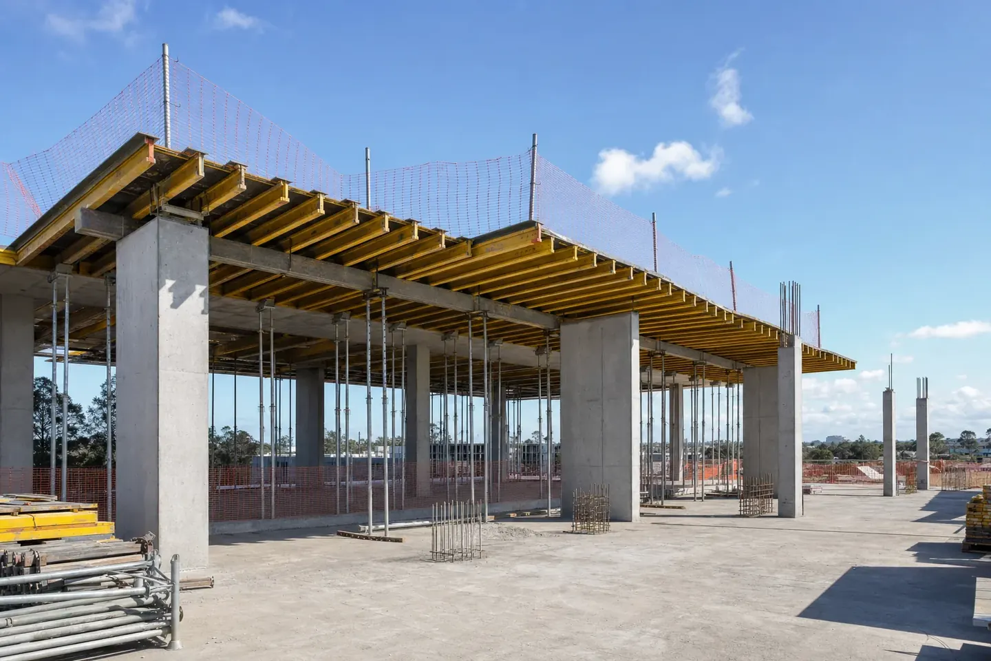 Commercial building site with concrete columns and suspended slab formwork propped above