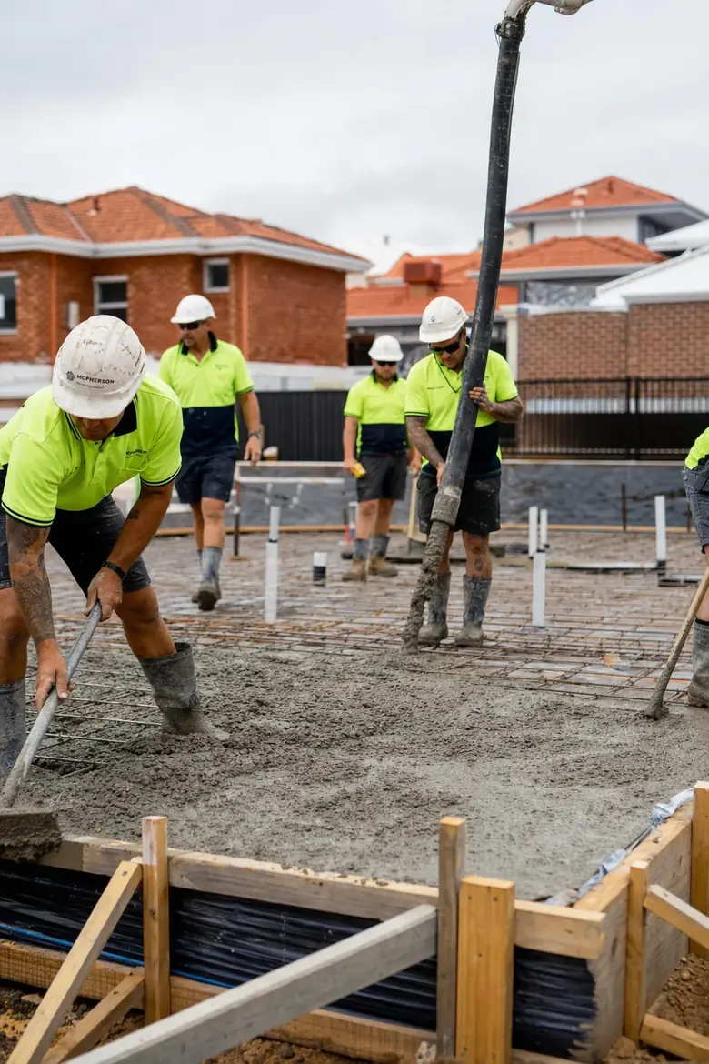 Perth concreters in hi-vis PPE pouring a residential slab with a boom pump
