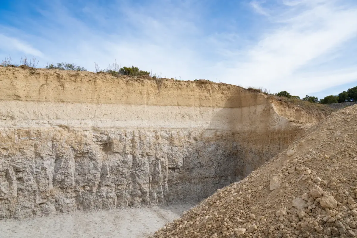 Open excavation face on a Perth site showing coastal sand giving way to limestone rock with depth