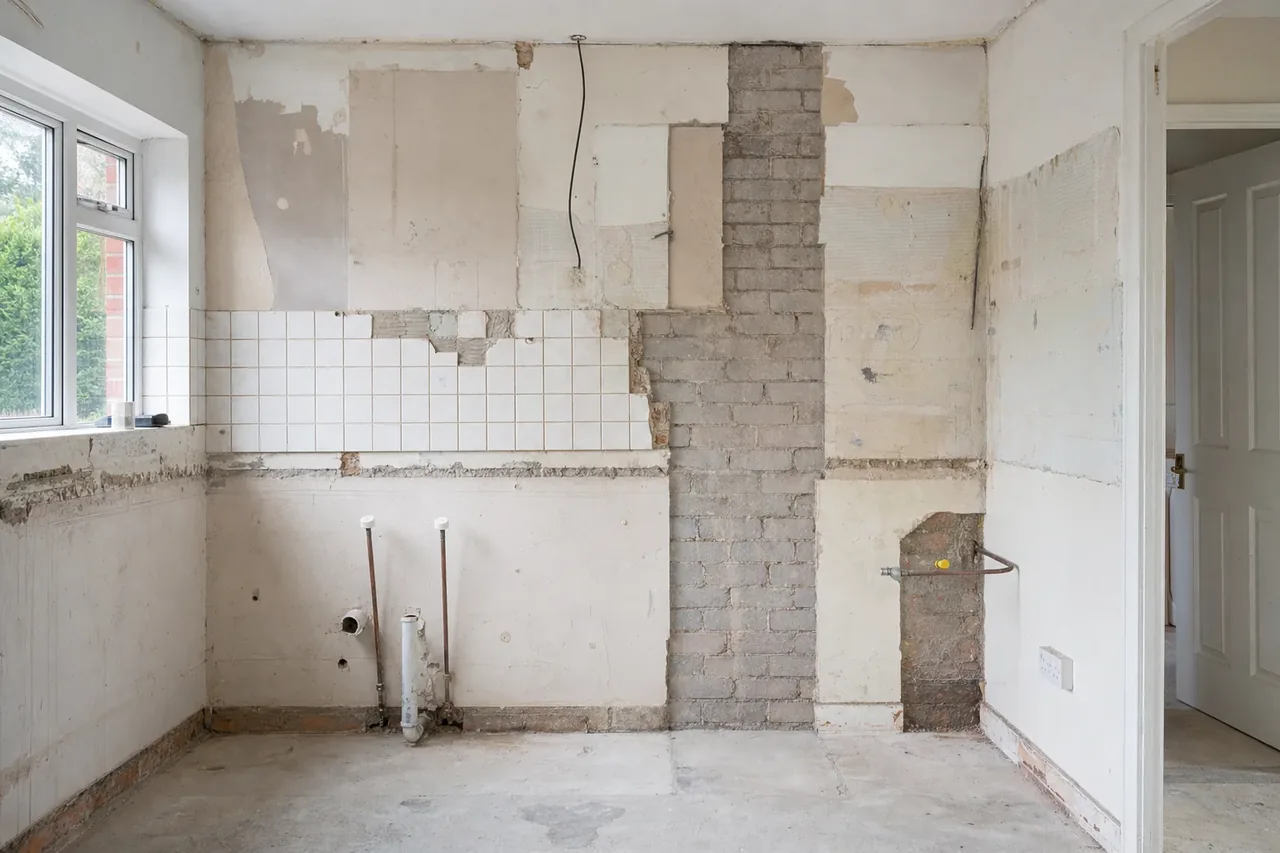 Stripped out kitchen during a Perth renovation with capped services exposed in the wall